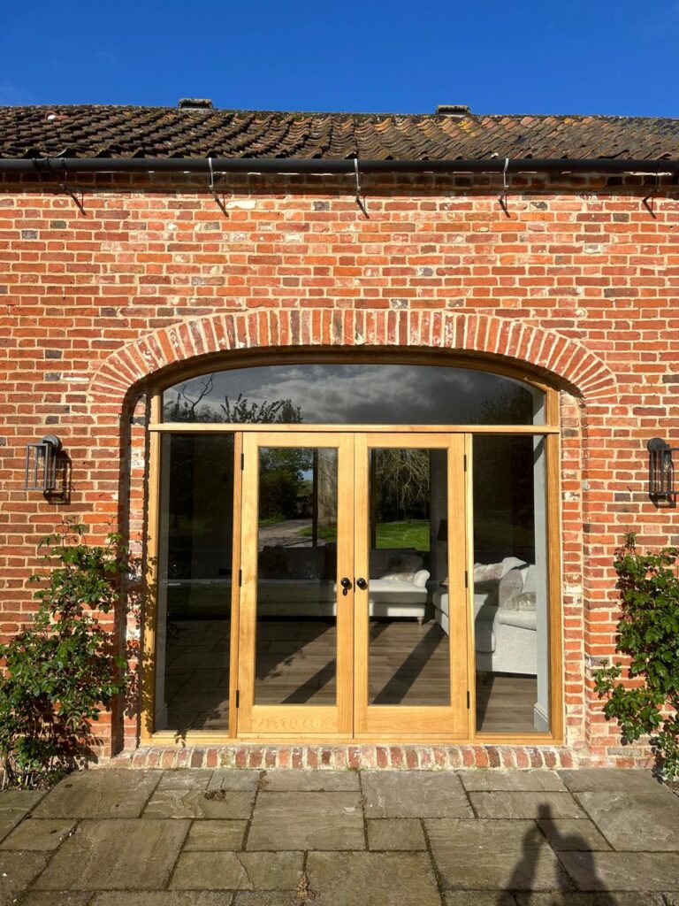 Painted timber French doors with glazing bars installed by Baker Builds