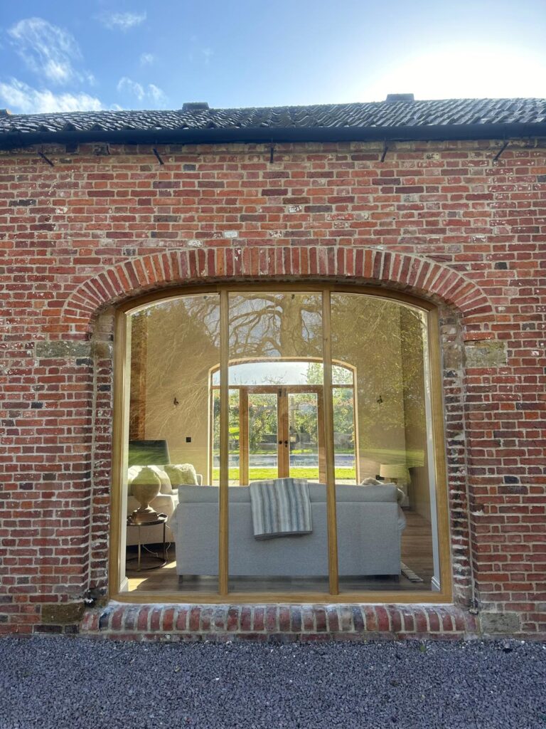 Arched timber window in an old brick building restored by Baker Builds